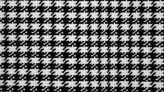 Classic houndstooth pattern fabric with high contrast black and white woven threads for luxury apparel design