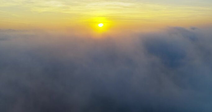 Magnificent sunrise above a vast sea of clouds, with golden sunlight streaming across the mist to create a dramatic and peaceful atmosphere. 