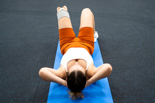 Woman with prosthetic leg training in gym, showing effort and self-improvement