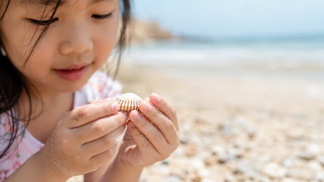 Young Asian Girl Holding Seashell on Sandy Beach During Summer Family Vacation