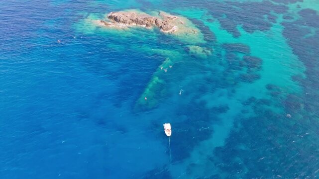 The Elviscot shipwreck resting in the crystal-clear waters off Pomonte on Elba Island, Tuscany, Italy, viewed from above and surrounded by the stunning Mediterranean coastline.