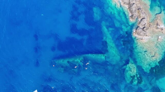 Aerial view of the historic Elviscot shipwreck lying in the clear Mediterranean waters off Pomonte, Elba Island, Tuscany, Italy, surrounded by a rocky coastline