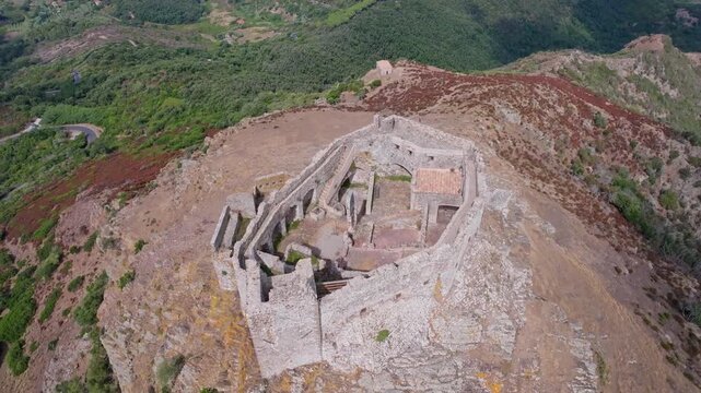 Aerial view of the medieval Castello del Volterraio perched on a rocky hill above Portoferraio, Elba Island, Tuscany, Italy, surrounded by Mediterranean vegetation.