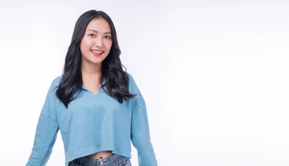 Portrait of a beautiful smiling young Asian woman in casual blue sweater looking at camera isolated on white background with copy space. Happy female student or casual lifestyle concept. © kaew6566
