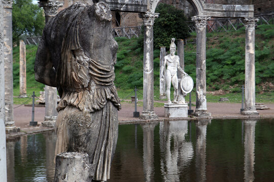 Statua classica del dio Ares tra le antiche colonne corinzie del Canopo a Villa Adriana riflesse sulla superficie della vasca, Tivoli, Italia