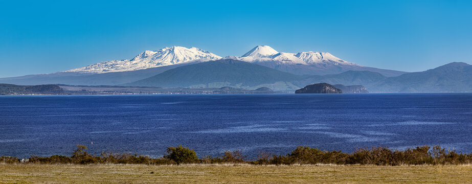 Lake Taupō, New Zealand, snowy volcanoes Mt Ruapehu, Ngauruhoe and Tongariro. Mt Pihanga, Tūrangi town, Motutaiko Island. Panoramic view.
