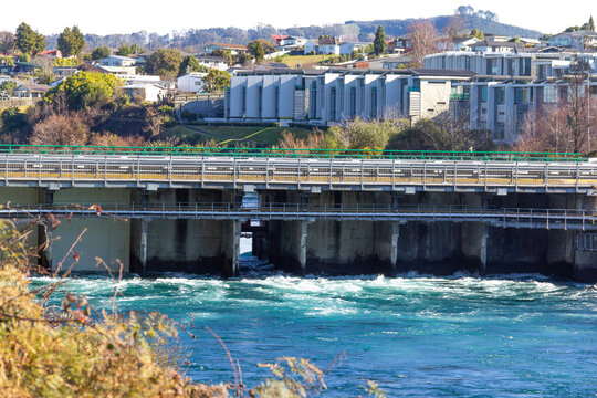 Control Gates bridge at Taupō, New Zealand, regulating water flow from Lake Taupō to Waikato River, supporting downstream hydroelectric generation. Suburb of Nukuhau in background.