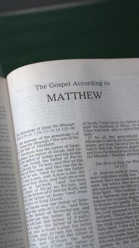 Opening to the book of Matthew of the New Testament in the Holy Bible. New Revised Standard Version. Vertical video.