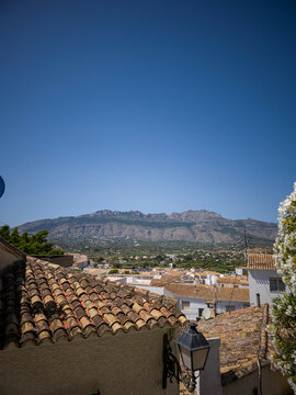 Scenic view of Altea coastal town with terracotta roofs and mountain range under blue sky during clear weather