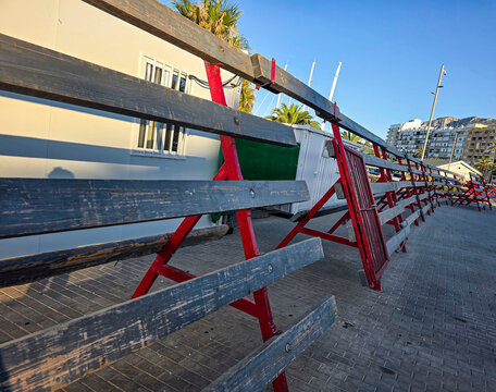 Traditional wooden bull run barricades with red metal frames ready for the encierro festival in a Spanish street