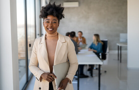 Young happy successful business woman working in corporate office