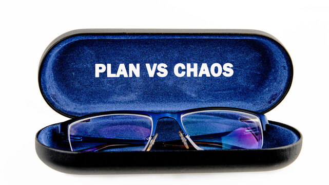 A glasses case is open showing a pair of glasses inside. The lid has the words plan vs chaos printed in bold letters. The scene is simple and focused on the contents