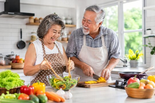 Senior couple preparing fresh healthy vegetables together in home kitchen
