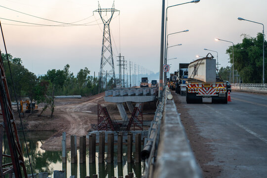 Bridge Construction Site with Precast Concrete Girder Installation over River at Highway Infrastructure Project