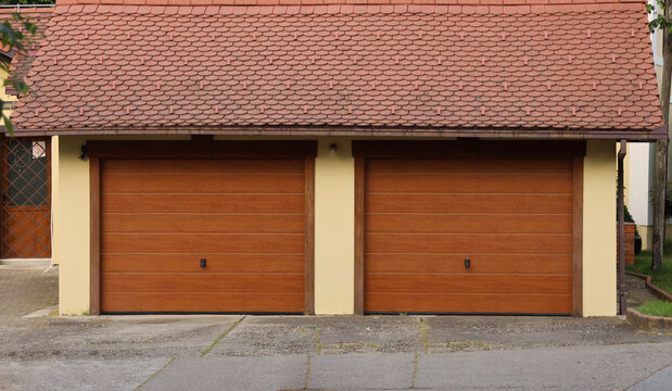 New concrete brick garage with tiled roof brown wood wooden roller shutters for 2 two cars