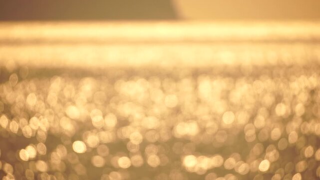 Bokeh sunlight water golden shimmering abstract blurred surface reflections peaceful tranquil