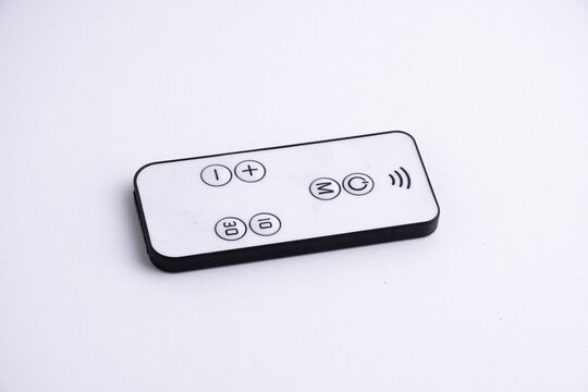 Modern white remote control isolated on white background flat lay and top view