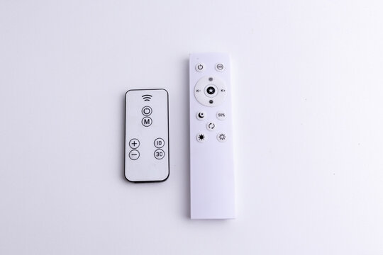 Modern white remote control isolated on white background flat lay and top view