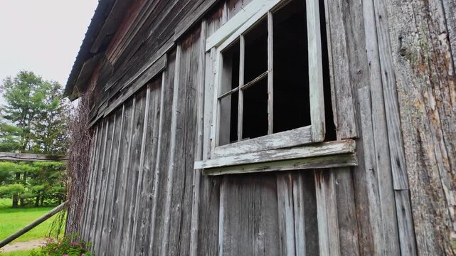 Old weathered wooden barn with a broken window on a foggy day in rural Leelanau County, Michigan