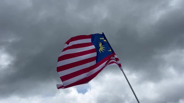 Malaysia flag waving against cloudy sky