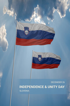 Two flags of Slovenia in blue sky with clouds for National holiday