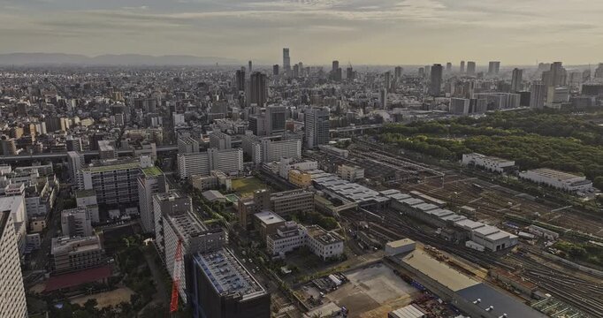 Osaka Japan Aerial v65 flyover above Morinomiya train yard and Osaka Castle Park, revealing the castle, Chuo and Joto skyline at sunset - Shot with Mavic 3 Pro Cine - Oct 9th 2023