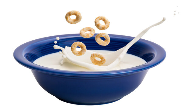 Round cereal rings splashing into blue bowl of milk with spoon, isolated on transparent background