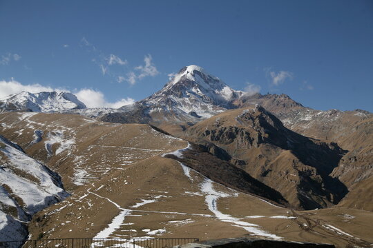 Mount Kazbek towering above the Caucasus Mountains on a clear autumn day.