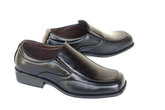 Pair of black leather slip-on dress shoes isolated on a white background. Classic formal footwear for business, office, work, school, and special occasions with a timeless and elegant design.