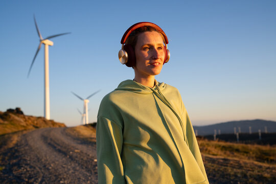 A white woman enjoys music outdoors