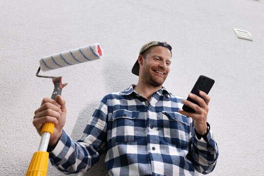 Happy construction worker receiving new job orders on phone during house renovation. handyman service, online booking