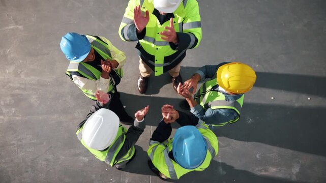 Team, huddle and architect with hands together in warehouse above for construction success. Top view, people or group of contractors piling with applause for winning, celebration or unity in depot