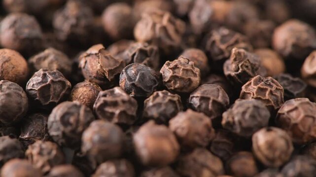 Whole black peppercorns filling the frame close up macro
