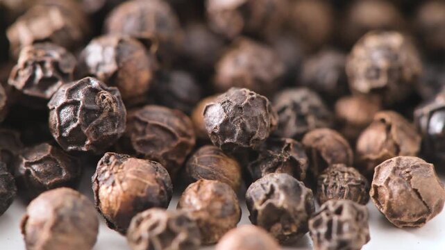Whole black peppercorns filling the frame close up macro
