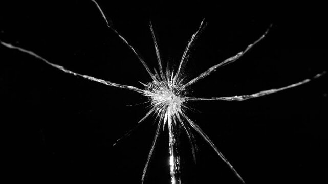 Cracks glass fracture effect texture isolated abstract black background. Realistic Glass impact crack with detailed fractures on a black background. For overlay, simulating broken glass effects. 