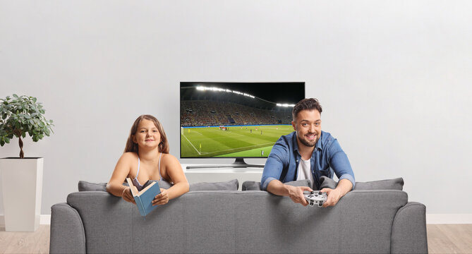 Man playing football video game and girl reading a book