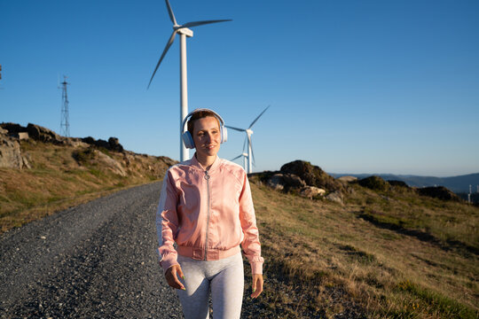 A white woman walking on a gravel path