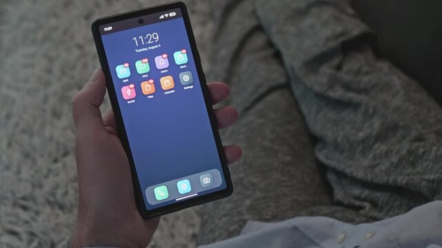 Smartphone in male hand showing home screen with growing unread alert badges, useful for technology and social network application promotional videos.