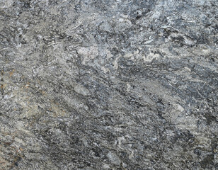 Fototapeta premium Horizontal abstract uneven boulder surface with porous rises, indentations, mineral bands, black specks, blue and brown tinting across gray stone