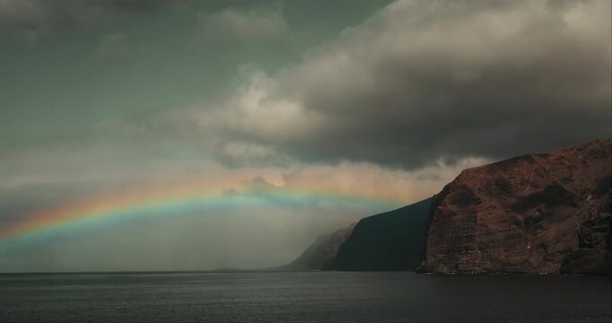 Rainbow Over Calm Ocean Waters and Steep Volcanic Cliffs in Tenerife