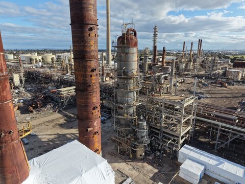 Industrial refinery decommissioning showing rusty towers and pipes