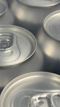 Rows of sealed aluminum cans are grouped in multipacks, creating a clean commercial display suitable for wholesale supply, retail sales and beverage distribution. Close up.