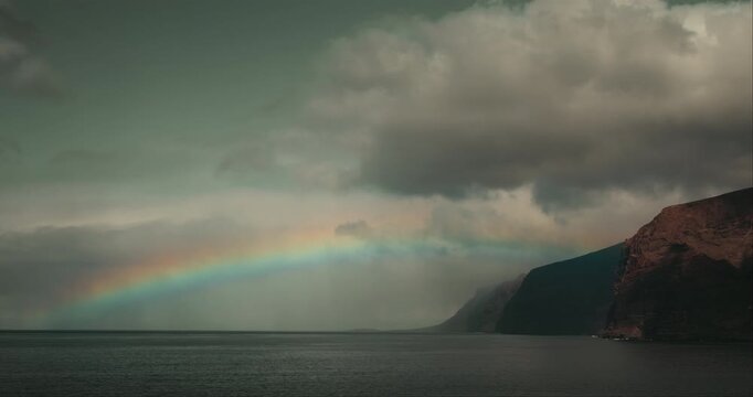 Wide View of Rainbow Over Ocean and Volcanic Cliffs in Tenerife Spain