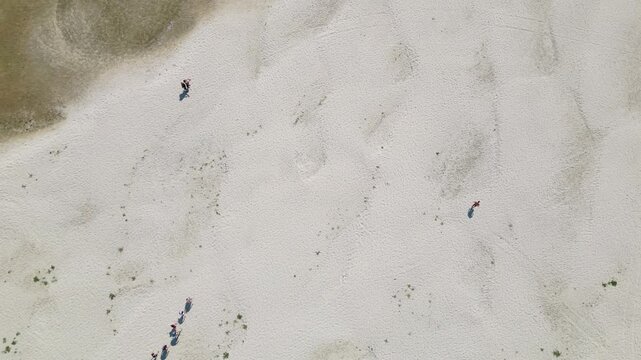 Wide aerial drone video of a group of people walking across the vastly exposed, dried up Danube riverbed near Apatin during severe summer drought and low water levels. APATIN, SERBIA - AUGUST 4, 2026