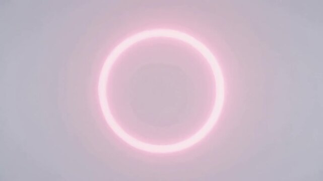 Pink solar eclipse ring against pale sky background