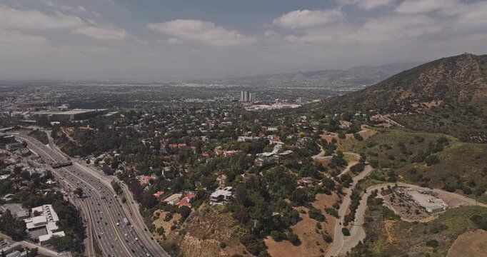 Los Angeles California Aerial v281 low flyover around Hollywood Hills, revealing Highway 101, Universal City, hillside homes, reservoir and downtown - Shot with Mavic 3 Pro Cine - May 26th 2024