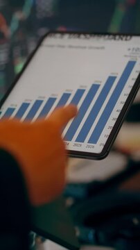 tablet displaying stock market growth margin chart interactive analytics. Close-up of investor hand pointing at financial performance data on screen