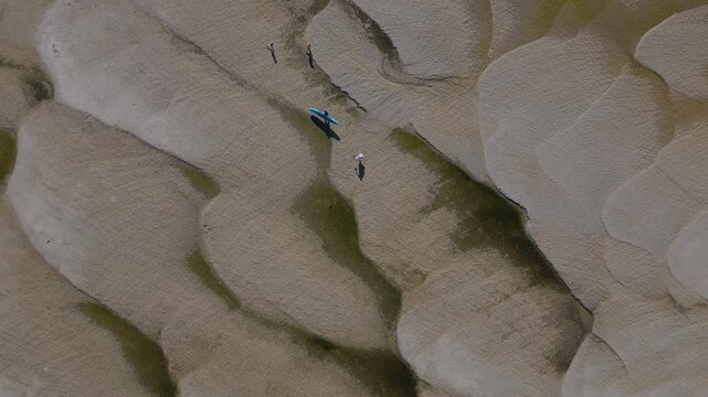 Wide aerial drone video of a group of people walking across the vastly exposed, dried up Danube riverbed near Apatin during severe summer drought and low water levels. APATIN, SERBIA - AUGUST 4, 2026