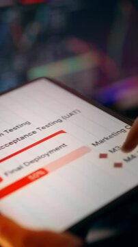 Unit testing integration user acceptance roadmap financial dashboard analytics tablet. Close-up hand pointing at interactive process flowchart screen showing unit