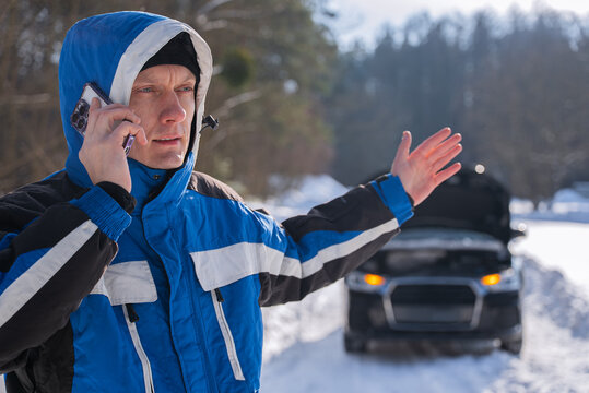 Man call roadside assistance for car breakdown in winter